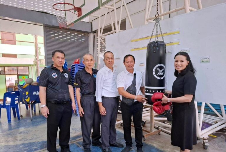 Pa Mok Municipality mayor Police Colonel Ronakorn Wongphumani (center) and executive committee members present Muay Thai training equipment to Pa Mok Community School at Wat Pa Mok on January 20, 2026, including a heavy bag, boxing gloves, and training gear to support youth sports development and keep students away from drugs.